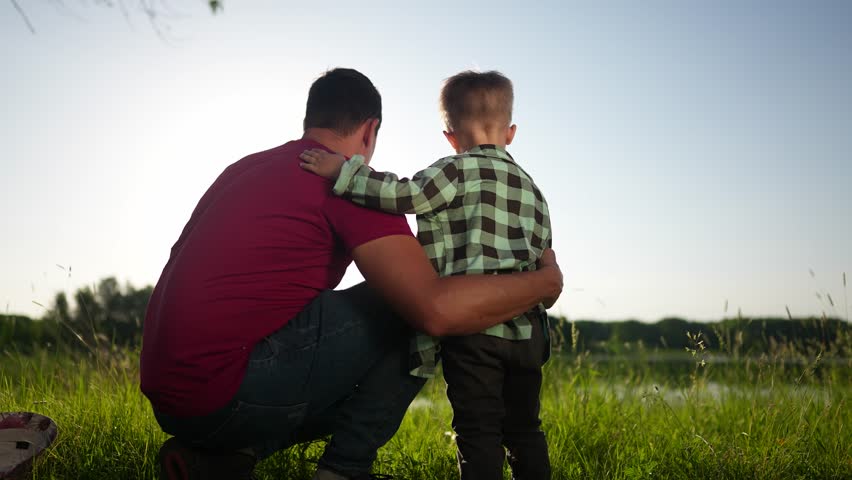 father and child son. father hugging his son by the river in the park in nature in summer waving their hands. happy family kid dream concept. father and son relaxing in the park lifestyle Royalty-Free Stock Footage #1108872861