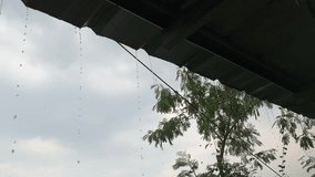 video of rainwater dripping from the roof of the house. plus swaying due to wind accompanied by heavy rain