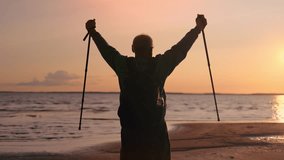 Happy elderly man silhouette Scandinavian walking stick raising hands win gesture at sun sunset sea beach. Old male healthy lifestyle physical activity cardio sport celebrate victory triumph at coast - Powered by Shutterstock - Get 15% off with code: PIKWIZARD15