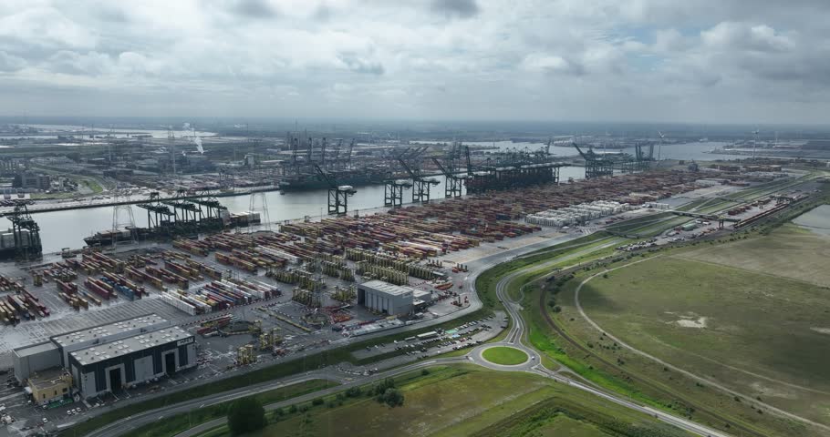 Aerial drone view of container port logistics, large-scale shipping of goods worldwide, and the transportation industry in the Port of Antwerp, Belgium, one of the largest ports in Europe