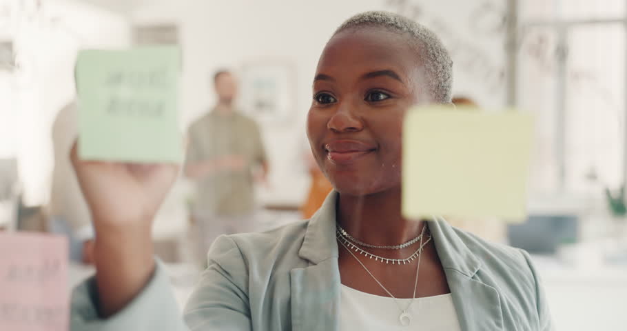 Creative, idea or black woman writing on sticky note planning agenda, marketing strategy or brainstorming. Focus, business or African employee working on startup company or development project ideas