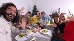 Happy multi generational family having online video call with smartphone app while sitting together on table at dinner christmas celebration. POV screen phone view. - Powered by Shutterstock - Get 15% off with code: PIKWIZARD15