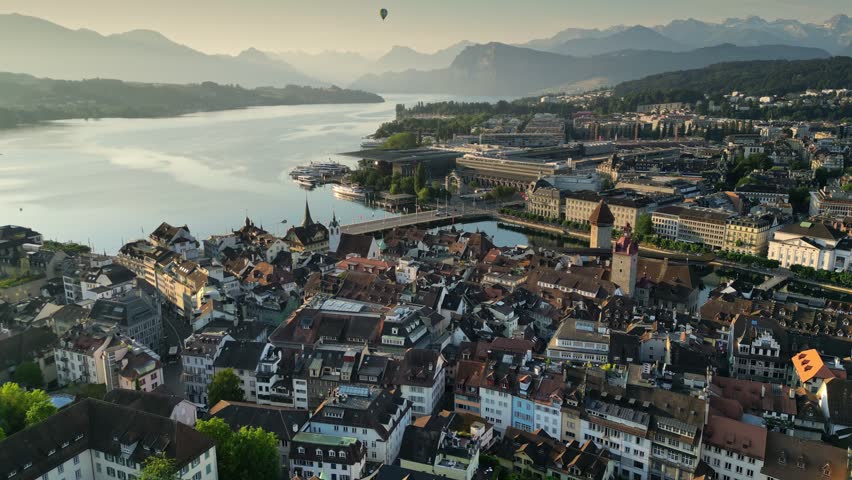 Chapel Bridge and old town of Lucerne. Flight at sunrise over city of Luzern, Swiss Alps and Lucerne lake on background Royalty-Free Stock Footage #1108891553