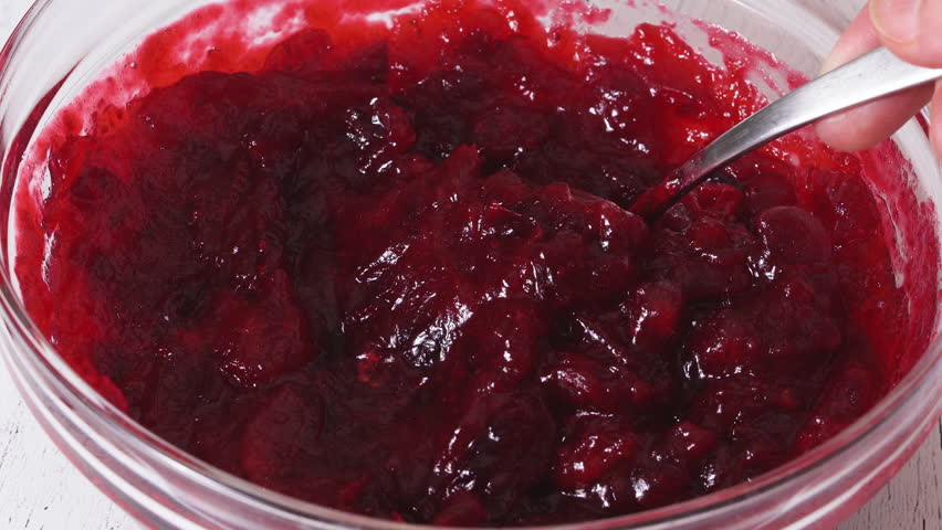 Close-up view of cranberry sauce in a glass bowl, flat lay