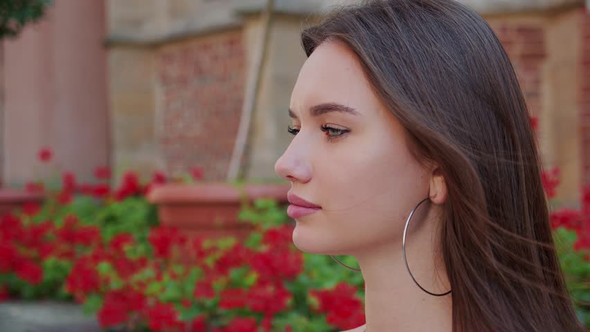 Closeup face of beautiful girl with long hair. Portrait of gorgeous girl looking to camera