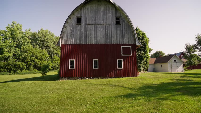 push in shot of an old red and white barn on a sunny day with birds flying Royalty-Free Stock Footage #1108900243