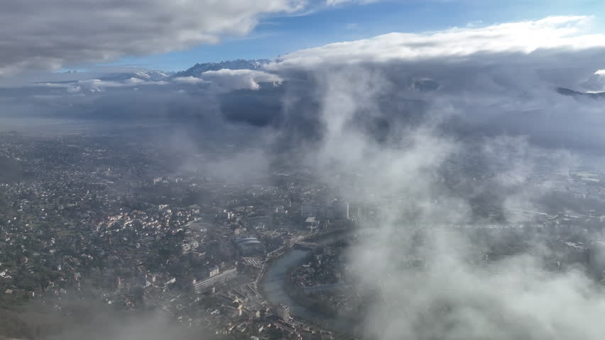 high altitude aerial shot over Grenoble city France sunny day mountains in background 
