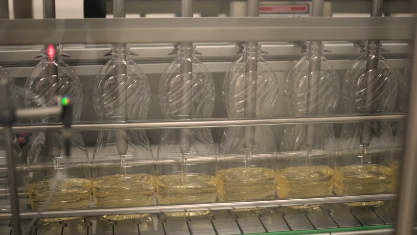 Sunflower oil in the bottle moving on production line. Bottling line of sunflower oil in bottles. Vegetable oil production plant. High technology. Industrial background Royalty-Free Stock Footage #1108902139