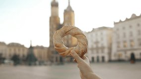 Close up of female tourist holding bagel obwarzanek traditional polish cuisine snack on the market square in Krakow in Poland. Traveling Europe. High quality FullHD footage - Powered by Shutterstock - Get 15% off with code: PIKWIZARD15