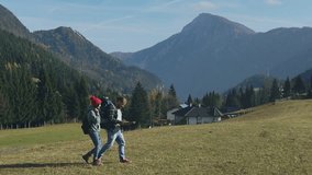 Young people hiker couple with backpacks navigate and searching the way in the mountains hiking route using smartphone map while hiking near Alps. trekking, nature, activity, exploration, adventure