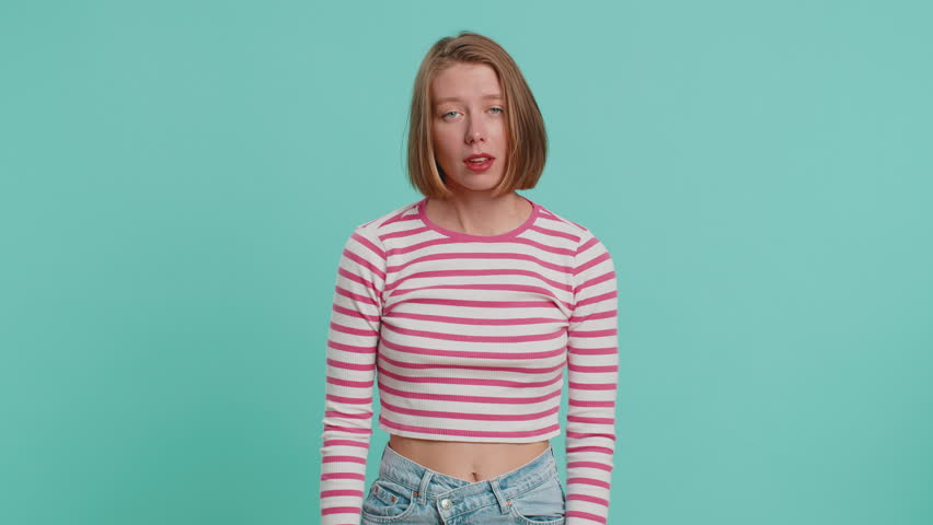 Dislike. Upset unhappy young woman showing thumbs down sign gesture, expressing discontent, disapproval, dissatisfied, dislike. Pretty girl in crop top. Indoors isolated on blue studio background Royalty-Free Stock Footage #1108904953