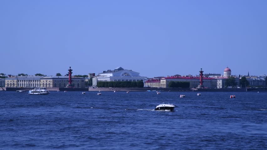 Tour boats sails on blue water of Neva river in a sunny summer day in Saint Petersburg city, Russia. Embankment of Vasilyevsky Island in the background. Real time video. Travel in Russia theme. | Shutterstock HD Video #1108909773