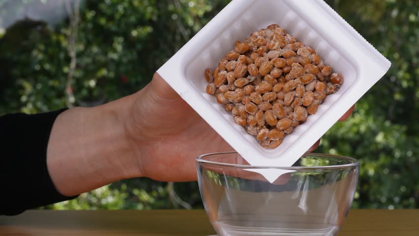 4k slow motion video of natto (fermented soybeans) being transferred from a pack to a glass container | Shutterstock HD Video #1108910297