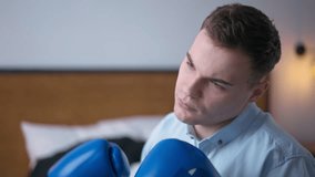 Close-up portrait of serious young businessman boxing shadow in slow motion looking away. Caucasian concentrated thoughtful man sitting indoors in home office - Powered by Shutterstock - Get 15% off with code: PIKWIZARD15