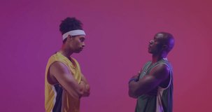 Animation of american flag over african american male basketball opponent players facing off. Sport, competition, confidence, flag, team, game, nationality and patriotism digitally generated video.