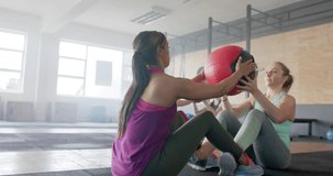 Animation of dna strands over diverse women cross training in pairs with medicine balls at gym. Fitness, exercise, strength, data, genetics and technology digitally generated video.