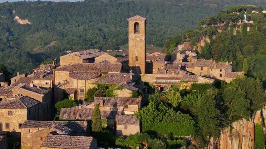 Civita di Bagnoregio, aerial view of an ancient Italian city standing on top of a plateau, illuminated by the sun. Famously known as the dying city. City on rock over Tiber river valley