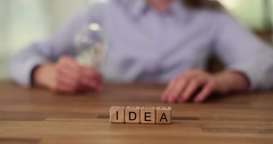 Hand of businesswoman holding light bulb and word idea. Innovation and inspiration concept | Shutterstock HD Video #1108919331