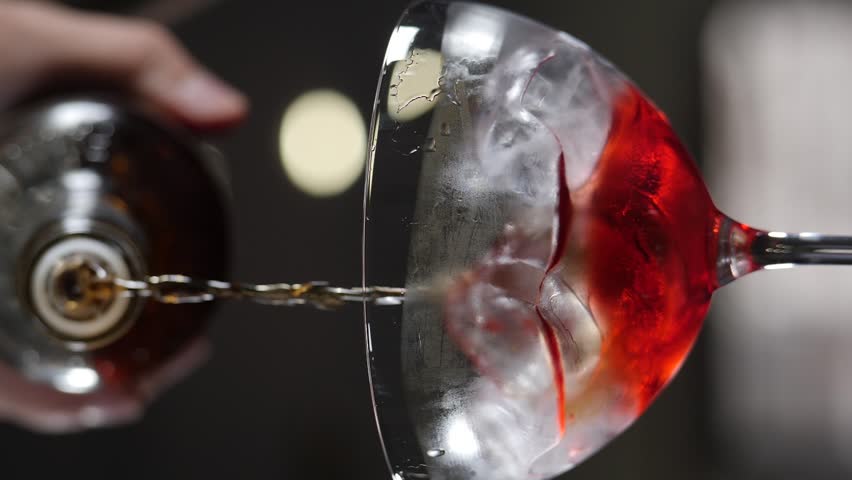 Bartender pouring liquid out of bottle to make cocktail closeup. Vertical footage. Slow motion. Refreshing iced beverage. Cool spirit filling alcohol drink cup. Making tasty lemonade for party bar | Shutterstock HD Video #1108919809