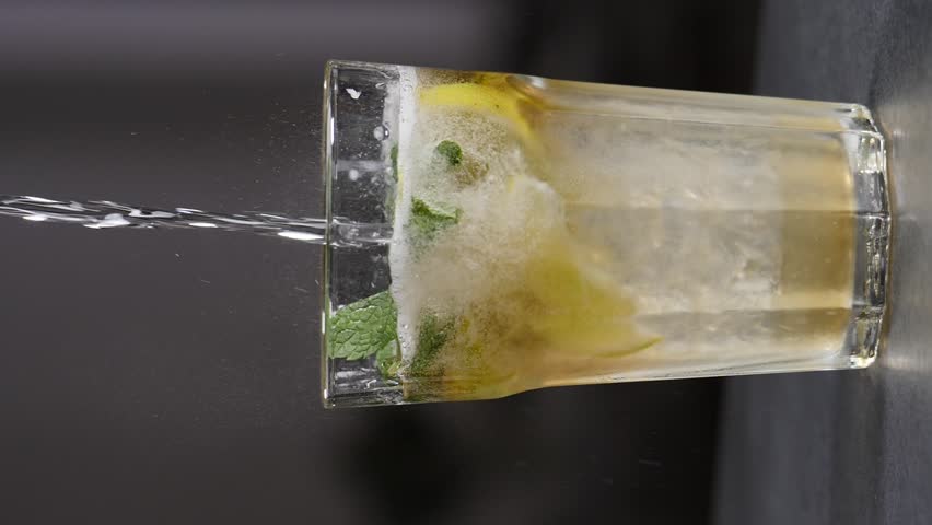 Barman Combining Ingredients to cook mojito cocktail. Vertical footage. Slow motion. Summer refreshing classic beverage. Soda filling non alcoholic drink with mint lime slice. Making fizzy mojito | Shutterstock HD Video #1108919813