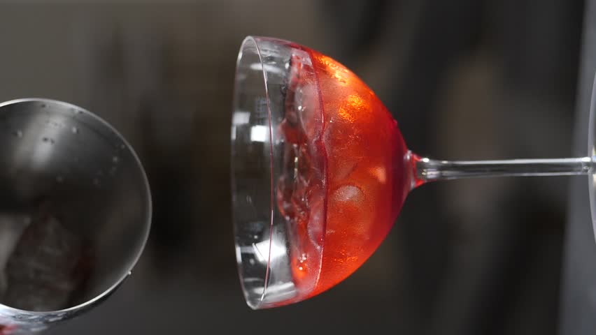 Ice cubes Falling into Glass of Fresh Cocktail in nightclub bar. Vertical footage. Adding ice to beverage. Slow motion. ice cubes being thrown into glass and splashes. Full hd | Shutterstock HD Video #1108919827