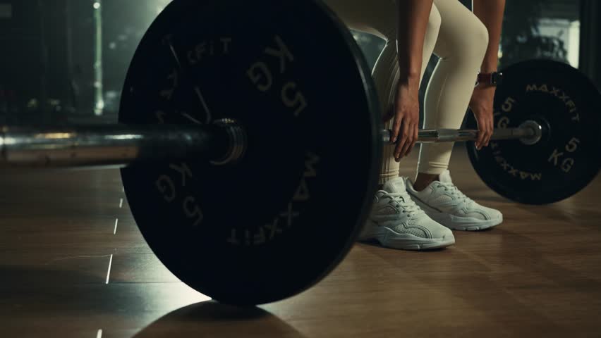 Young woman doing deadlift with heavy bar in gym, strong female athlete with muscular body lifting weights, exercising with barbell. Royalty-Free Stock Footage #1108924835