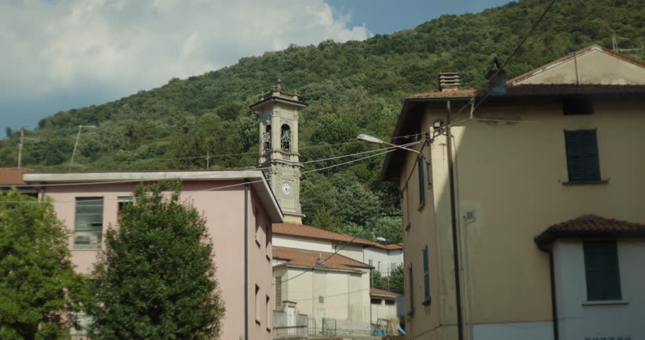 Beautiful church in a small hamlet or village in Lombardy, Italy.  Street view POV, point of view from the car of a little borough near Switzerland. The cathedral is dedicated to Saint Ambrose.