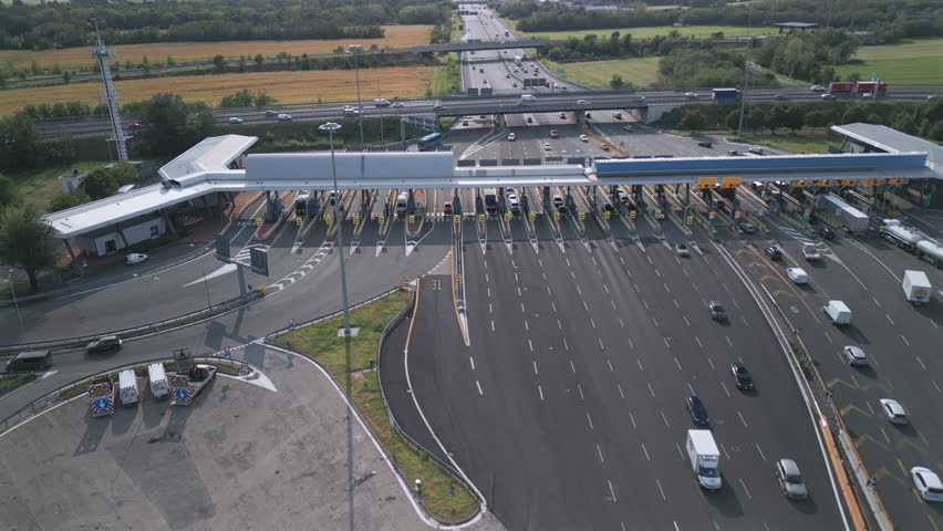 Aerial view of an Italian highway toll booth. Time-lapse cars queuing up to pay the highway toll and automatic paying lanes.