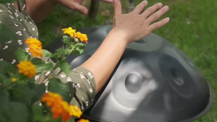 a woman plays on handpan or hang