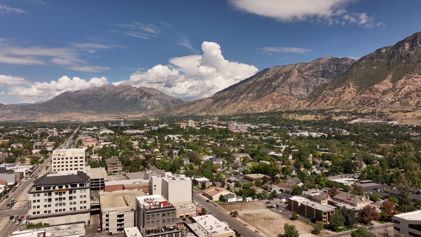 Aerial Provo Utah neighborhood to business buildings pull 2. Urban city office, buildings and business headquarters along street with busy traffic. Vehicles driving road intersection. Buildings. Royalty-Free Stock Footage #1108944673