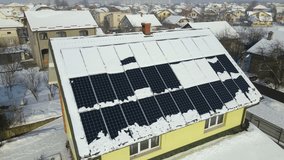 Aerial view of house roof with solar panels covered with snow melting down in winter end for producing clean energy. Concept of low effectivity of renewable electricity in northern region - Powered by Shutterstock - Get 15% off with code: PIKWIZARD15