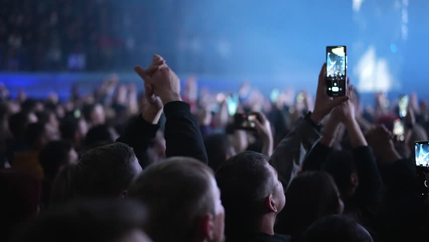 Lot fun people record music video use mobile phone. Fan crowd shoot k pop live concert. Many men hang out cool rave fest. Joy group chill night club hall. Dj star raise hand up. Make neon light photo.