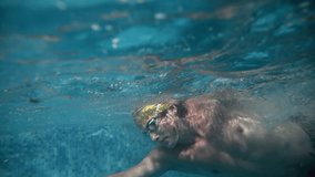 Underwater view of professional swimmer training in swimming pool, 4k 120 fps super slow motion raw video. Triathlete swim in black wetsuit  - Powered by Shutterstock - Get 15% off with code: PIKWIZARD15
