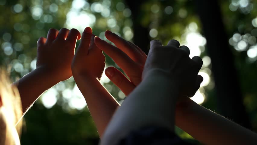 Close up hands of happy dreaming girl and woman play with sun.  Silhouette of hand in sun.  mom and daughter hands reach out to the sun silhouette sunlight. happy family kid dream concept.  Royalty-Free Stock Footage #1108957019