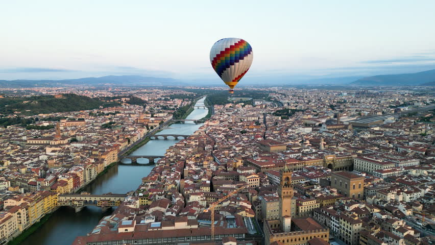 Florence, Colorful hot air balloon epic flying above the city at sunrise, Cathedral of Saint Mary of the Flower, Palazzo Vecchio, Ponte Vecchio, Tuscany, Italy Royalty-Free Stock Footage #1108958069