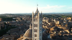 Siena Cathedral or Duomo di Siena, a medieval church in Siena, Italy. Drone orbit shot at sunset