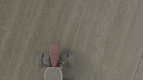 Big red Tractor Pulling Disc Harrow Through Field in Preparation soil for Planting new crops, Agriculture. Aerial view of tractor plowing the field. slow motion, 10 bit ungraded D-LOG video