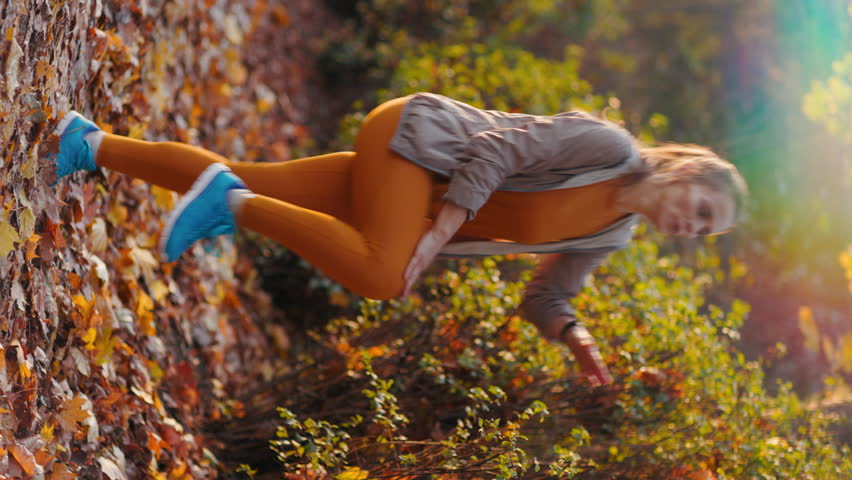 Hello autumn. Full length portrait of stylish woman in fitness clothes in the park workout.