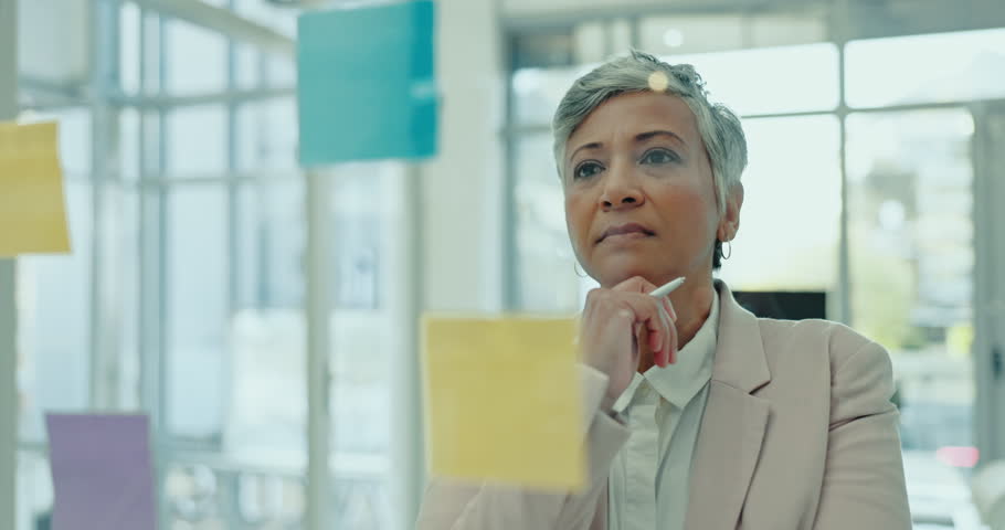 Sticky note, glass wall and mature business woman thinking of project idea, research and brainstorming advertising plan. Moodboard analysis, solution or executive CEO working on franchise development Royalty-Free Stock Footage #1108963815