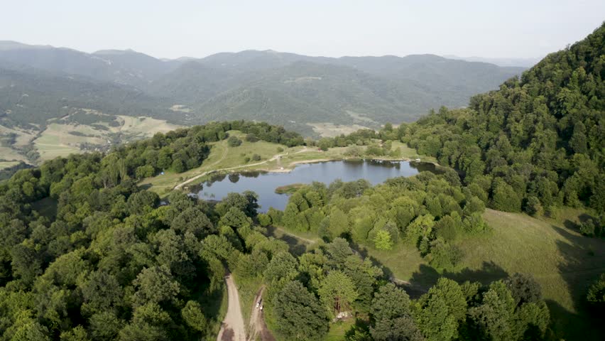 Aerial view lake in forest. "DSEGHI TSOVER" LAKE in  Lori Province, Armenia.  Lake Tsover, Dsegh, Armenia. Lori region.  Drone slowly fly around lake between green trees. Discovery Armenia.  Royalty-Free Stock Footage #1108965507