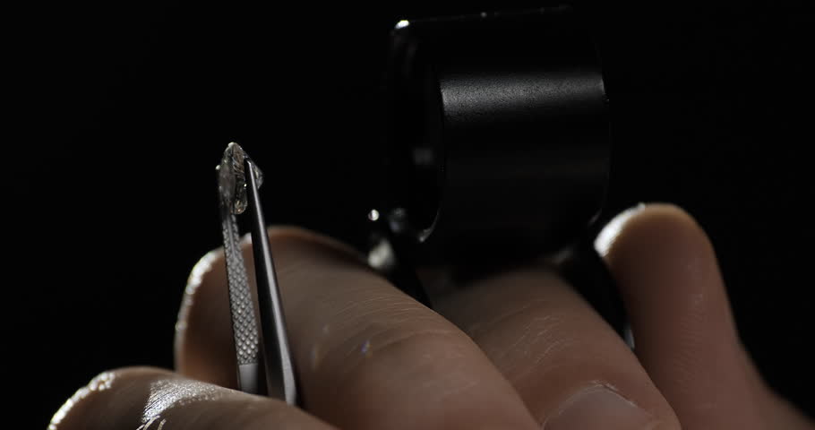 Gemologist checks diamond quality under magnifying glass. Diamond or gem grading and valuation. Close-up side view Royalty-Free Stock Footage #1108967091