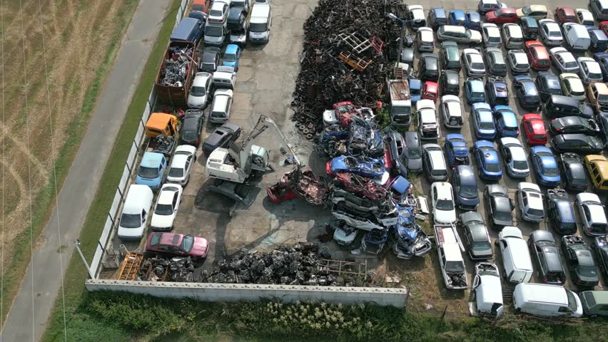 Aerial view of crane crashing scrap metal cars in a junkyard. | Shutterstock HD Video #1108968315