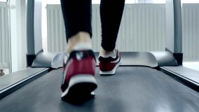 Leg of woman running on treadmill Low view sneakers training in sport club to workout with speed for a marathon or challenge