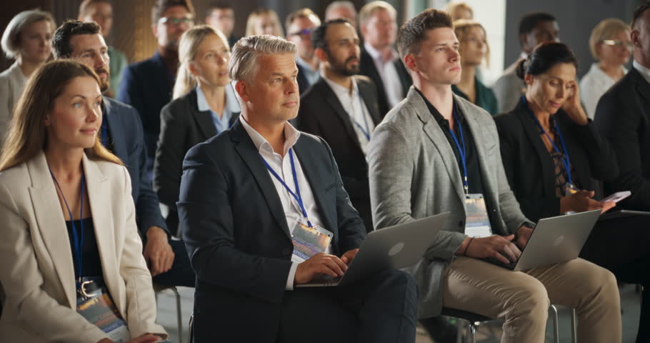 Caucasian Male Pharmaceutical CEO Sitting In Diverse Crowd At Medical Summit And Using Laptop Computer. Successful Man Listening To Presentations About New Developments In Biopharma and Medicine. Royalty-Free Stock Footage #1108971051