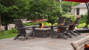static shot of a patio seating area that includes a propane fire pit surrounded by adirondack chairs - Powered by Shutterstock - Get 15% off with code: PIKWIZARD15