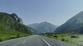 The car is driving on a mountain road with a magnificent scenery. Travel by car. Beautiful nature. Slow motion video