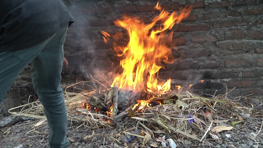 Summer fire concept, burning rubbish in the open in the yard, summer daylight, danger of air pollution and environmental pollution, Pinrang Indonesia, 22 September 2023 | Shutterstock HD Video #1108976615