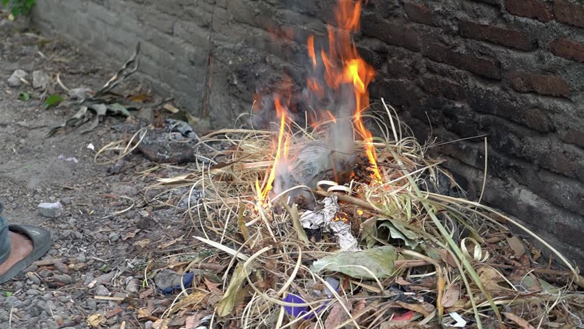 Summer fire concept, burning rubbish in the open in the yard, summer daylight, danger of air pollution and environmental pollution, Pinrang Indonesia, 22 September 2023 | Shutterstock HD Video #1108979511