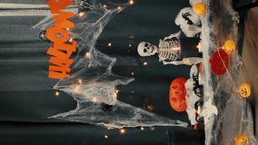 Halloween decoration in dark room. Halloween background with lighting pumpkin, candles and halloween traditional symbols. Preparation to celebrate Halloween party night. Trick or treat. Vertical video