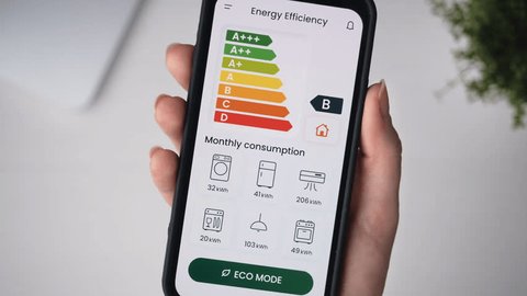 Turning on ECO mode using the energy efficiency rating app. Increasing savings by decreasing energy consumption of house appliances and making a green and eco-friendly smart home.: film stockowy